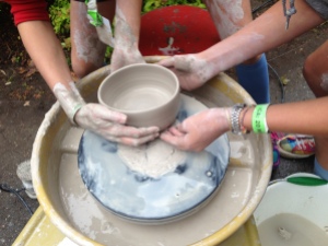 New potters collaborating to remove a bowl from the wheel